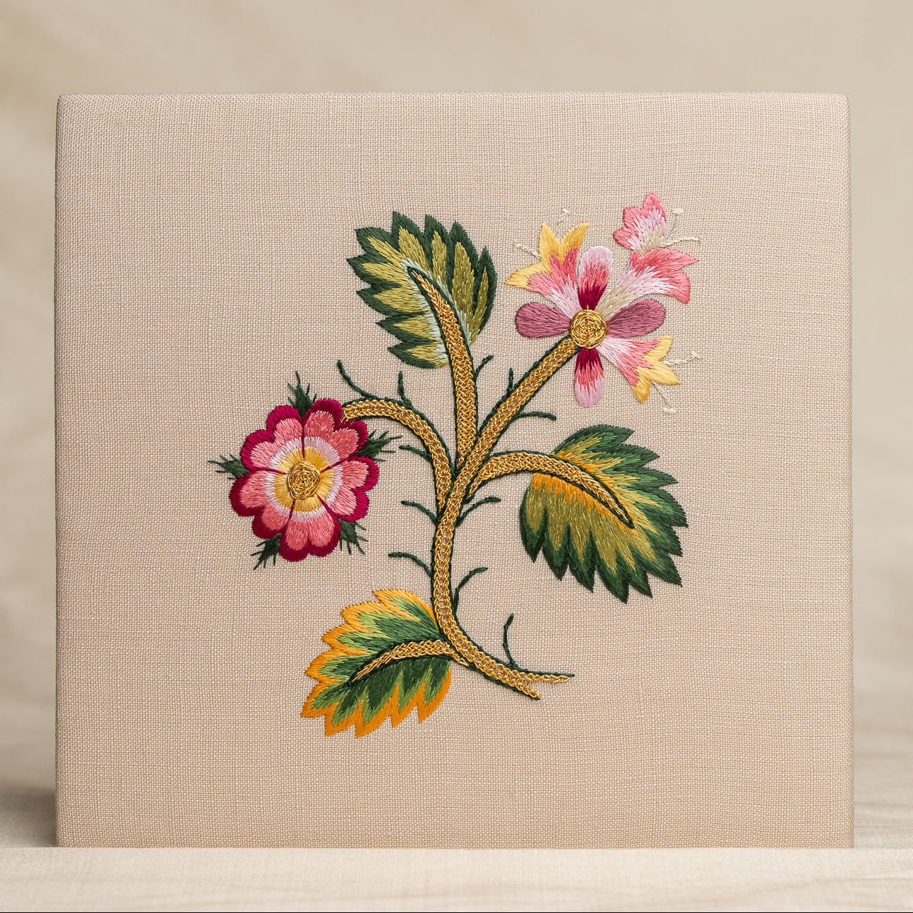 Embroidered floral design on a beige fabric background