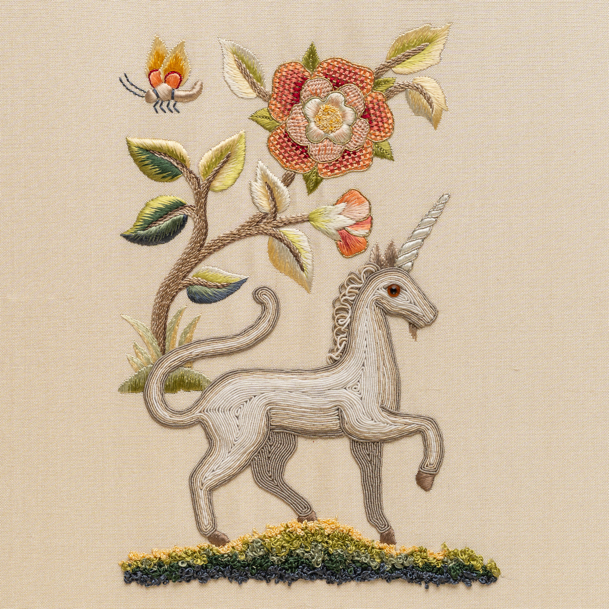 Embroidered design of a unicorn with flowers and leaves on a beige background