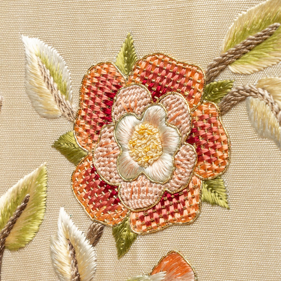 Embroidered floral design on fabric with a beige background