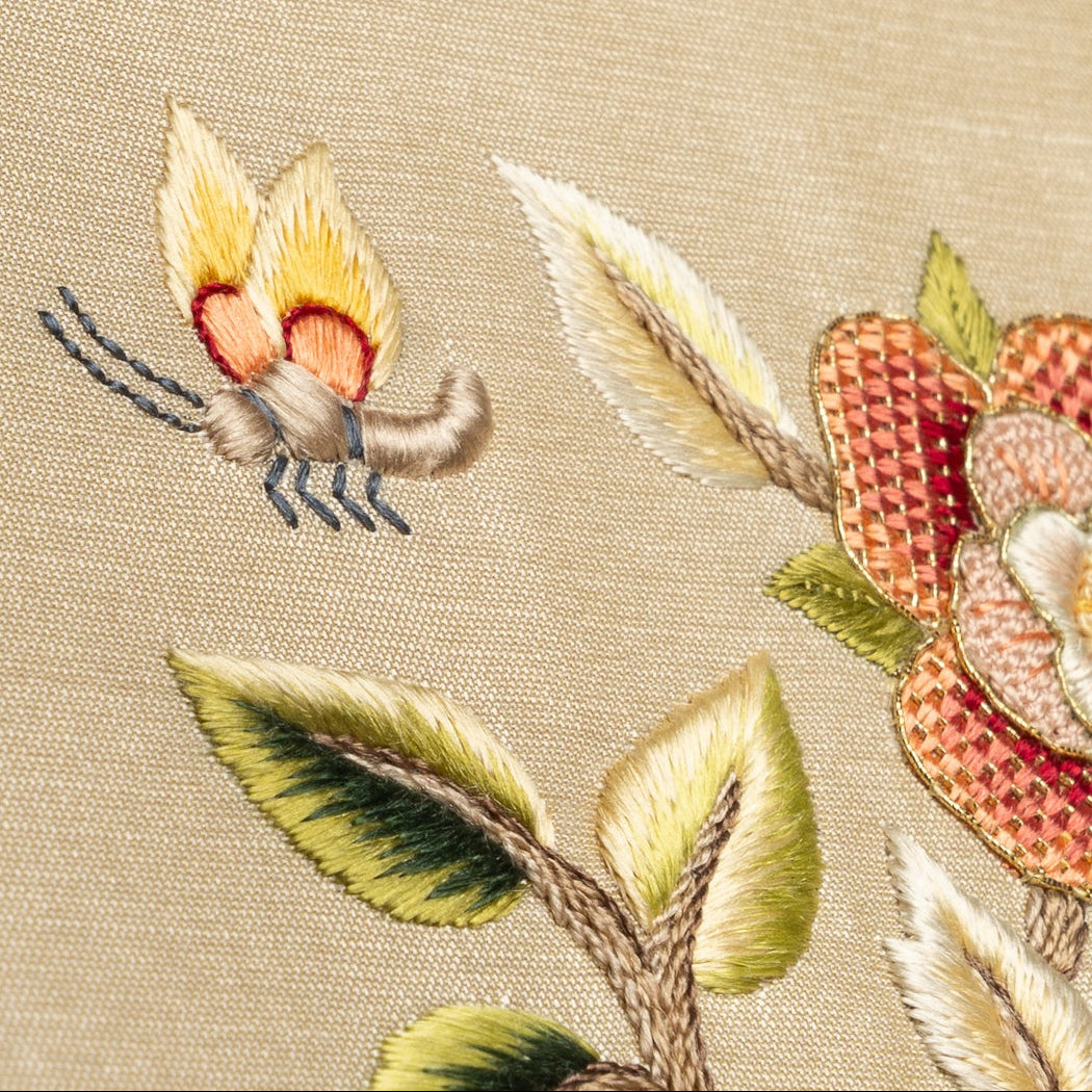 Embroidered design of an insect and flowers on beige fabric